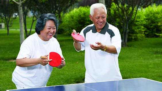 Older couple playing ping pong.